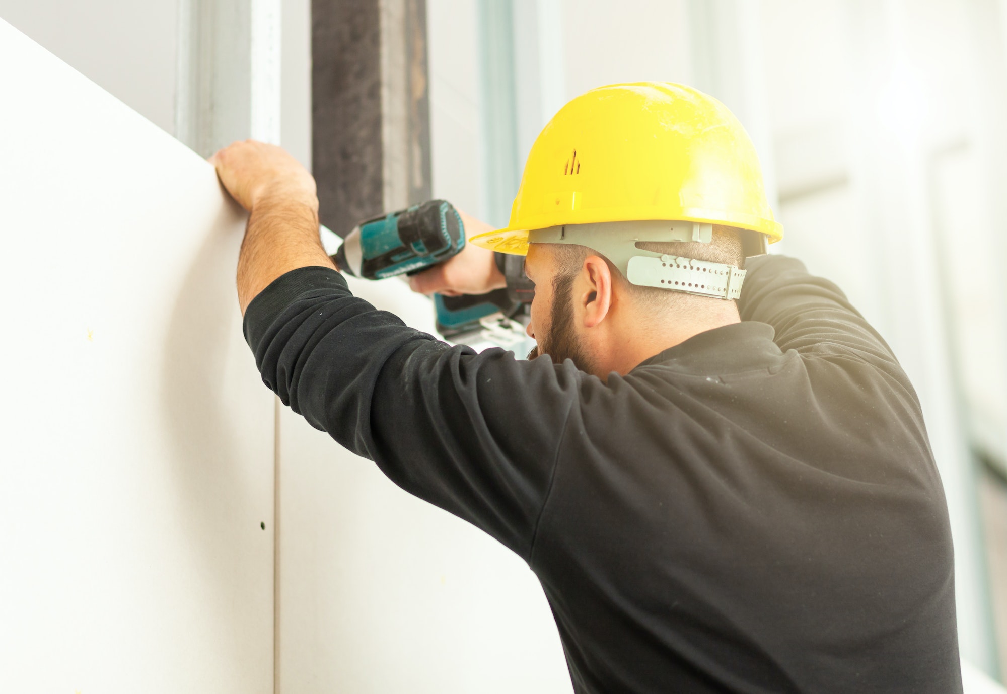 Worker builds a plasterboard wall.